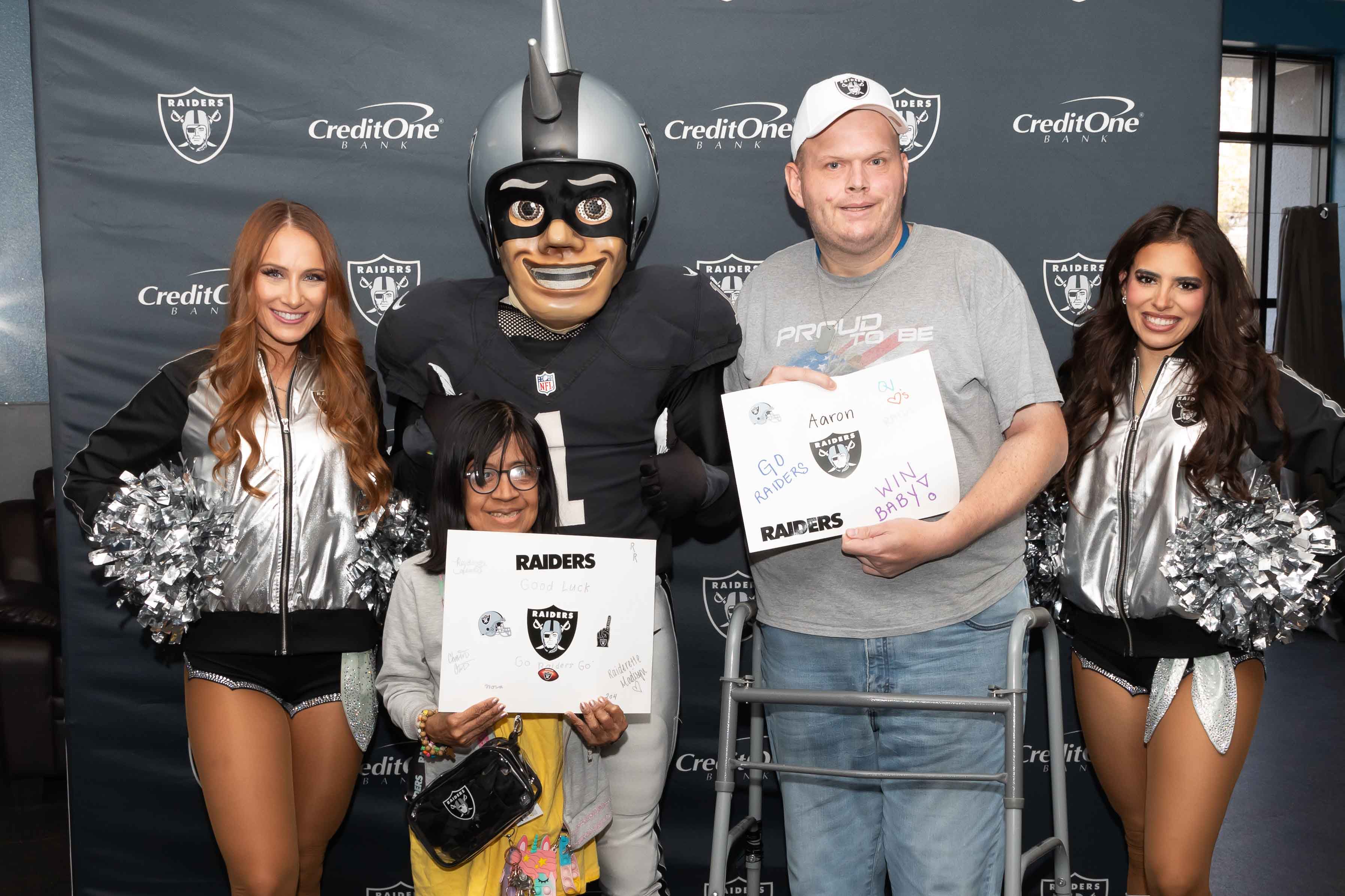 Group photo of Opportunity Village provocation program participants joined by Raiderettes and Mascot.