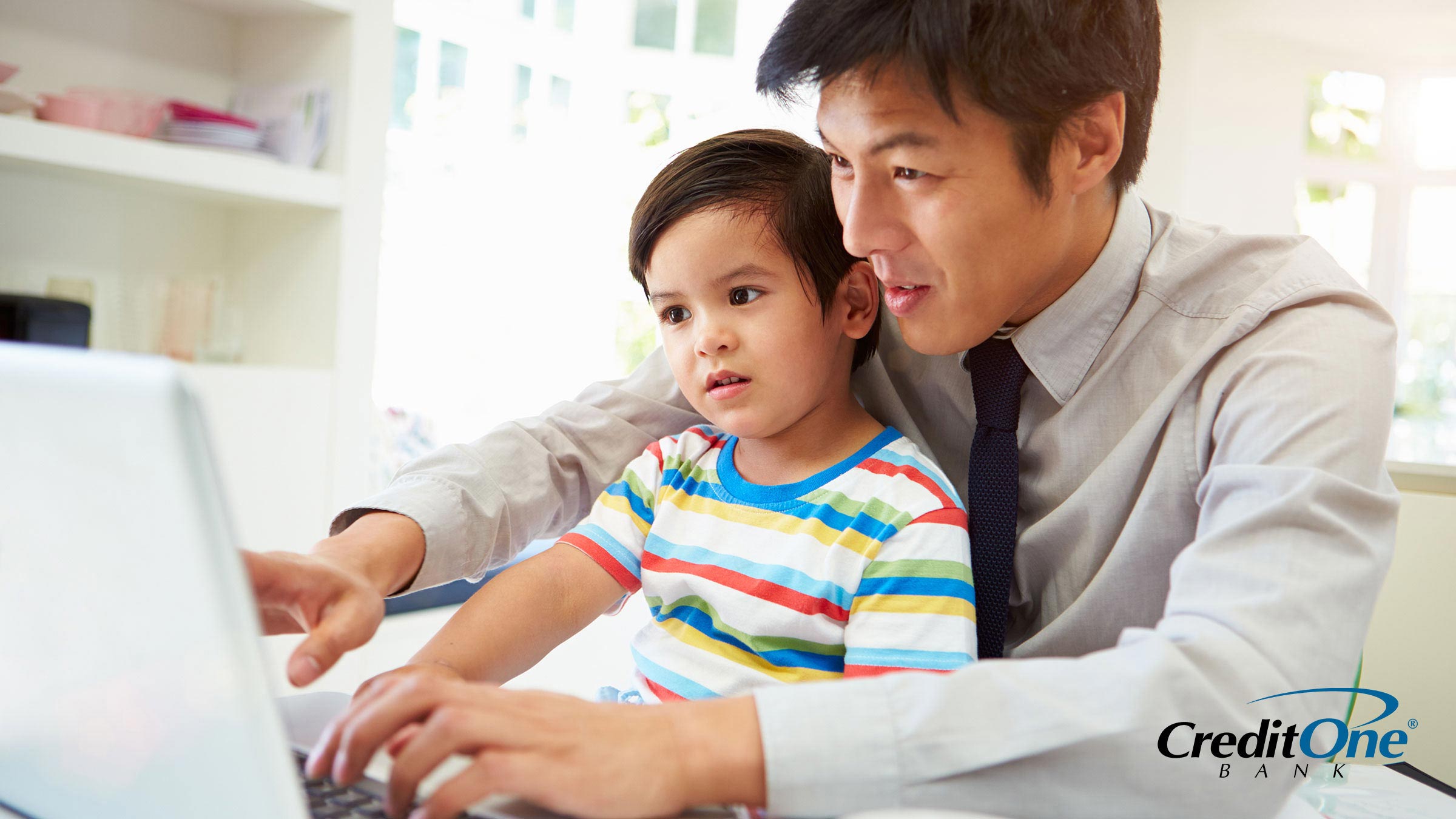 Father showing his infant son a budget on the computer