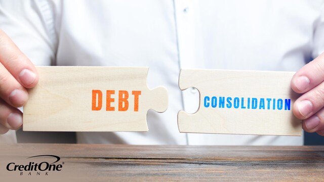 A man’s hands hold two wooden puzzle pieces labeled “Debt” and “Consolidation,” bringing them together to represent how multiple debts can be consolidated into one.