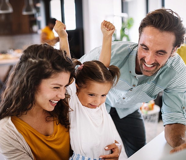Man, woman, and child in front of a laptop